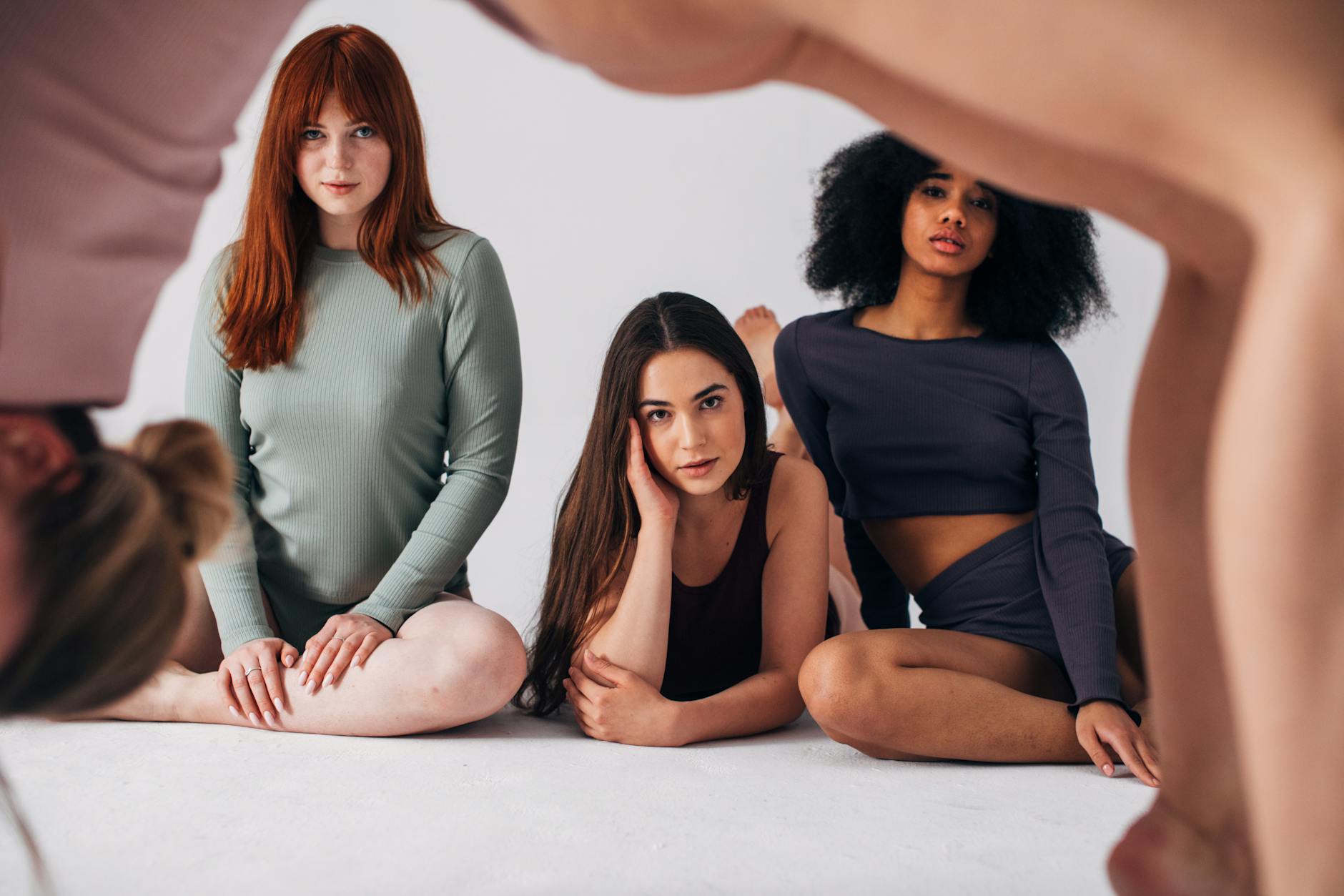 Diverse group of people sitting comfortably on yoga mats in a modern studio.